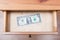 One dollar bill in open drawer