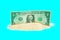 One Dollar Bill in a Pile of Sand on Blue Background