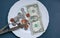 One dollar lying on the plate with fork and knife. No money photo. Poor people idea. Dimes and cents coins. Small salary and