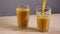 One empty glass filled refresh orange juice slowmotion white background closeup