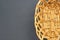 One empty oval wooden wicker basket for bread, fruits or others food products lies on dark scratched concrete table