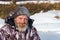 One euriopean bearded fisher man or hunter with ice and hoarfrost on beard is looking to the camera with smile