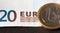 One Euro Coin and 20 Euro Banknote in background with EUR writing. Finance and personal wealth concept