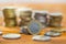 One euro coin on table with others stacked on pile in background