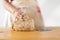 One female hand kneading dough on a wooden table