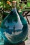 A one gallon glass bottle full of blue liquid outside of a craft shop in the KIONI port, ITHACA, Ionian Islands, Greece