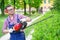 One gardener shaping hedge using hedge trimmer