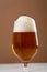 One glass amber golden beer overflowing food  background