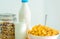 One glass of milk and milk bottle with blank label put on wood table near bowl of cereal with spoon. Calcium food breakfast