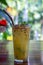 One glass of passion fruite on wood table in garden