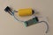 One green gray old plastic microcircuit with lead soldering with wires and a yellow small metal barrel