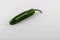 One green Serrano chili pepper.