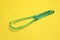 One green tongue cleaner on yellow background