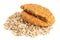 One and half crunchy oat and wholemeal biscuits on a heap of oats isolated on white