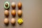 One half of row avocado, few chicken eggs and yellow rubber duck on a brown background, flat, top view