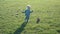 One and a half year old boy joyfully chases the ball on the field