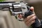 one hand is large silver heavy revolver and aims into the air