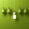 One hanging energy saving light bulb glowing different standing out from unlit incandescent bulbs