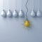 One hanging yellow idea bulb standing out from the dim unlit light bulbs on white wall background