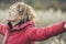 One happy woman outstretching arms in outdoor leisure activity with nature field in background. Serene female people enjoying day