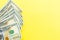 One hundred dollar bills cash lying on yellow background . Financial and business concept. Flat lay, mockup, overhead