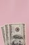 One hundred dollars banknotes on pink background. Flat lay, top view, copy space