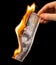 One hundred dollars burn in the hand on a black background