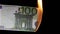 one hundred euros burning on a black background