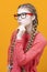 One Intelligent Clever Winsome Caucasian Blond Girl In Warm Knitted Sweater Posing with Glasses and Lifted Hand While Thinking And