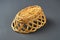 One inverted empty oval wooden wicker basket for bread, fruits or others food products lies on dark scratched concrete table