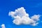 One isolated white cloud in a blue sky. Heaven background. Wallpaper. Beautiful cloudscape. Cumulus clouds. Weather forecast.