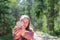 One joyful teen girl in forest holding a wooden heart in her hand.On spring nice day.Blurry background,copy space