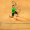 The one jumping player, caucasian fit man, playing tennis on the earthen court