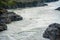 One kayaker on a yellow kayak floats on the mountain river Katun.