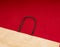 One Kraft paper recyclable bag with handles lie on a red background