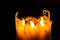 one large candle made of beeswax on a black background, seven small candles of beeswax in one, fire is burning.fire transmission.