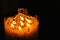 One large candle made of beeswax on a black background, seven small candles of beeswax in one, fire is burning.fire transmission.