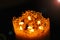 One large candle made of beeswax on a black background, top view of seven small candles of beeswax in one, fire is burning.fire tr