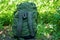 One large full backpack stands on the ground and in the green grass