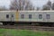 One large gray railway wagon with windows stands on the rails