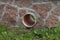 One large plastic drainpipe in a brown stone wall