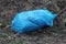 One large ragged blue plastic bag with garbage