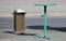 One-legged green metal outdoor table with trash can