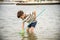 One little boy alone exploring the beach at low tide walking tow