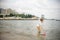 One little boy alone exploring the beach at low tide walking towards the sea coast. happy childhood concept