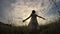 One little girl dancing in the field at the sunset time.