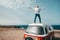 One man alone and isolated standing with opened arms on a minivan or camper having fun and smiling - digital nomad people