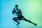 One man exercising thai boxing training on blue background in neon light.