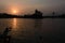 One man giving ganga river water to sun at sunrise morning at haridwar bridge temple sky