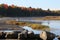 One man in a green canoe with yellow paddle, on Eel River, New Brunswick, Canada, in early morning.